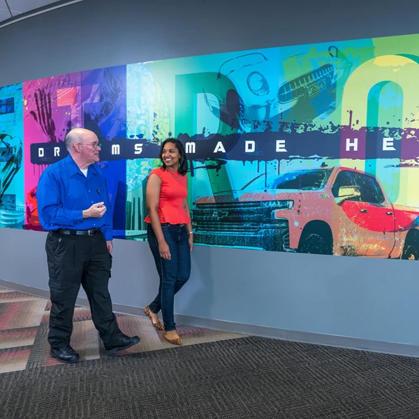 Two GM employees walking and talking.